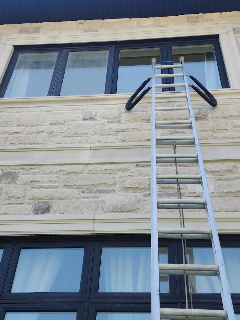 Upper-level window service on a stone façade